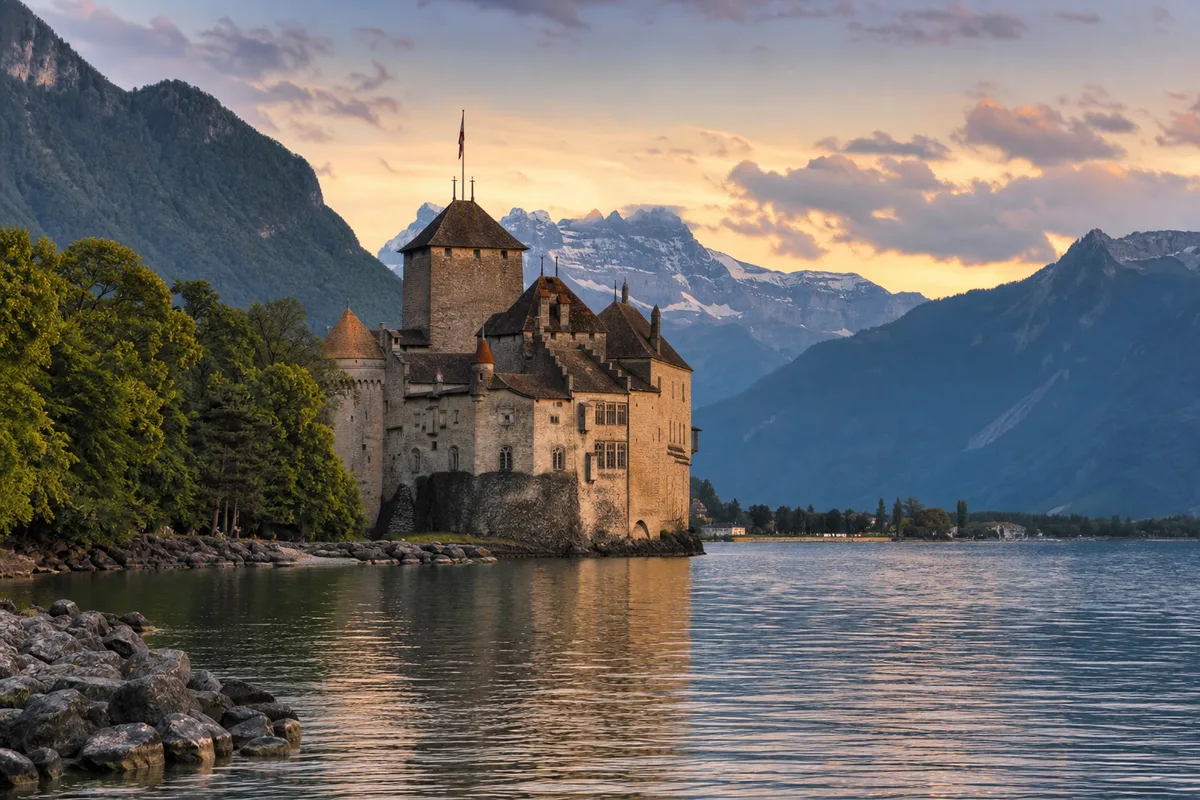 Vue d’un château au bord d’un lac alpin entouré de montagnes en fin de journée