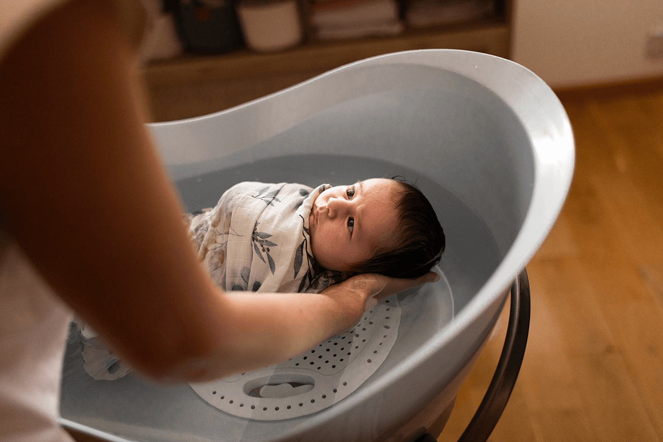 un bébé profite d'un bain sensoriel dans les bras de sa maman