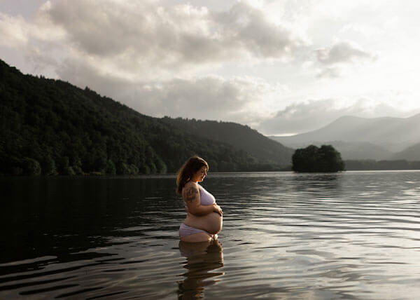 une femme enceinte prend la pause dans un lac