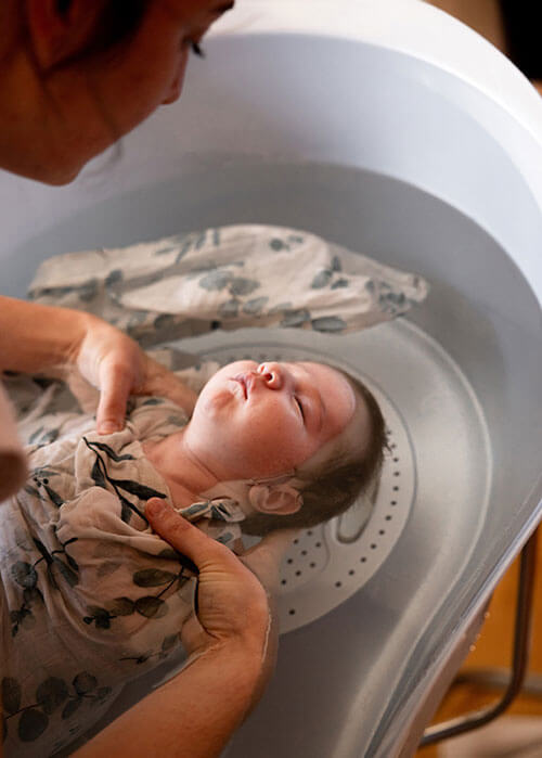 un bébé emmailloté dans un bain