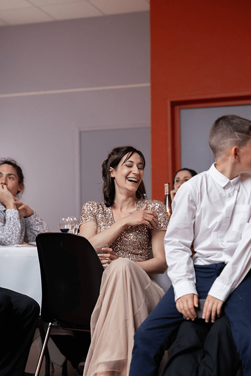 Une femme rit lors d'une soirée de mariage