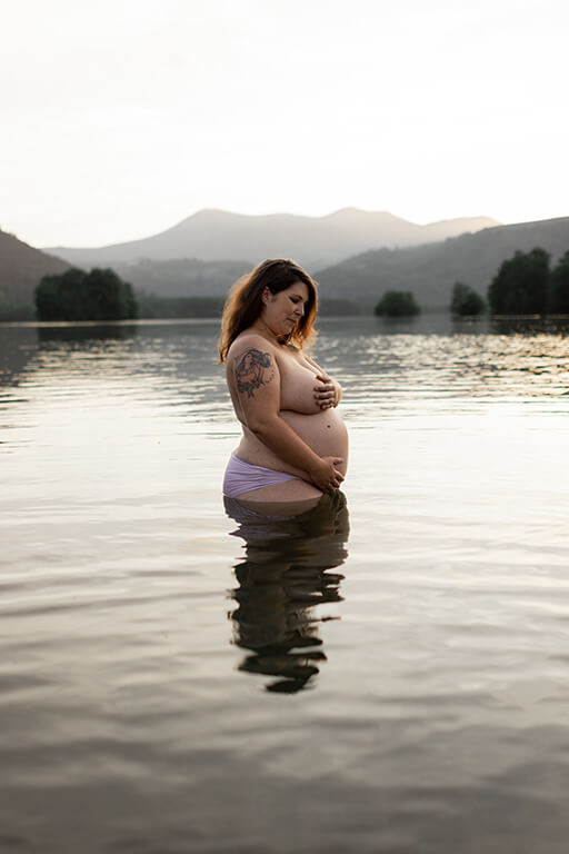 une femme enceinte de profil dans un lac