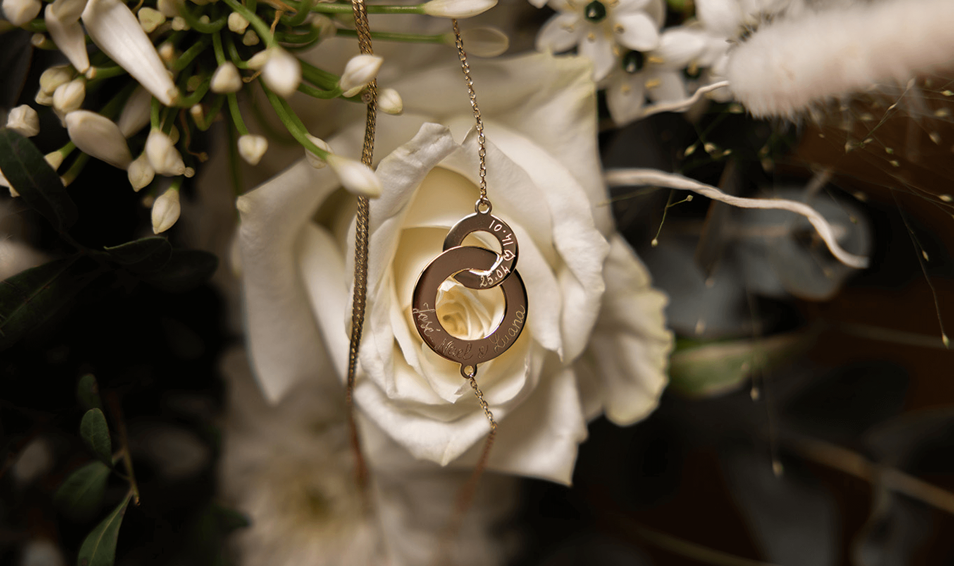 un collier de mariage devant une rose blanche