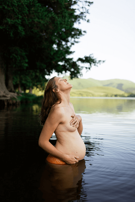 Une femme nue lors d'une séance photo de grossesse dans un lac d'Auvergne