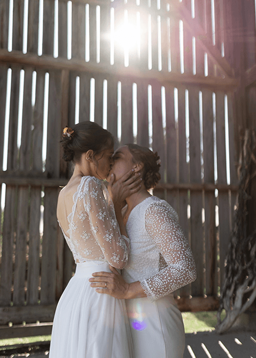 deux femmes en robes de mariées s'embrassent
