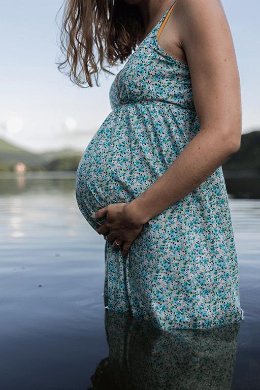 une femme en robe lors d'une séance photo de grossesse dans un lac d'Auvergne