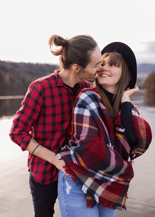un couple s'embrasse face à un lac