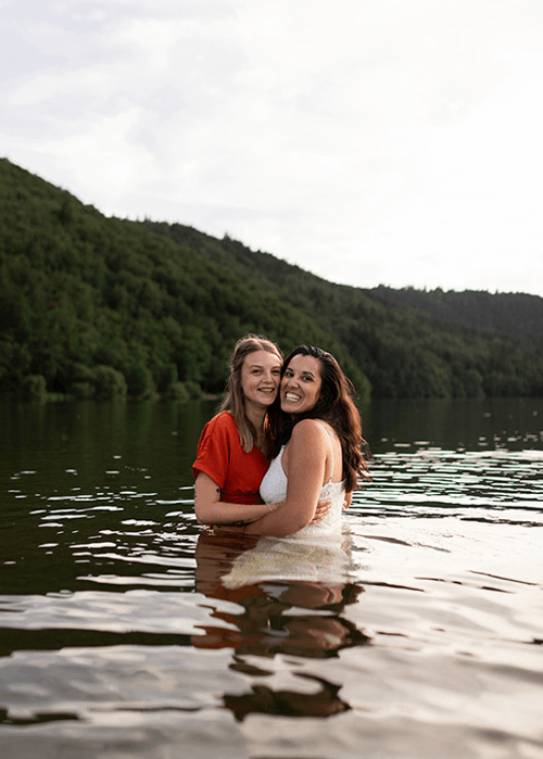 deux femmes dans les bras l'une de l'autre prennent la pause dans un lac