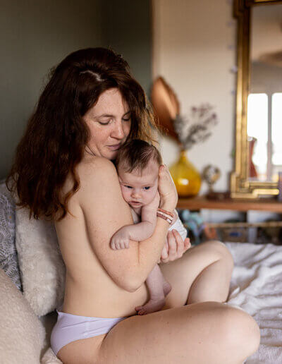 une femme porte son bébé en peau à peau