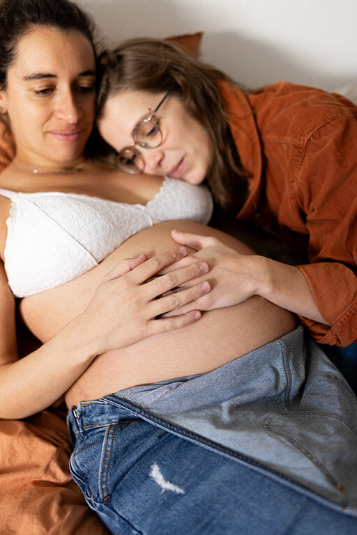 un couple de femme carresse le ventre de la femme enceinte
